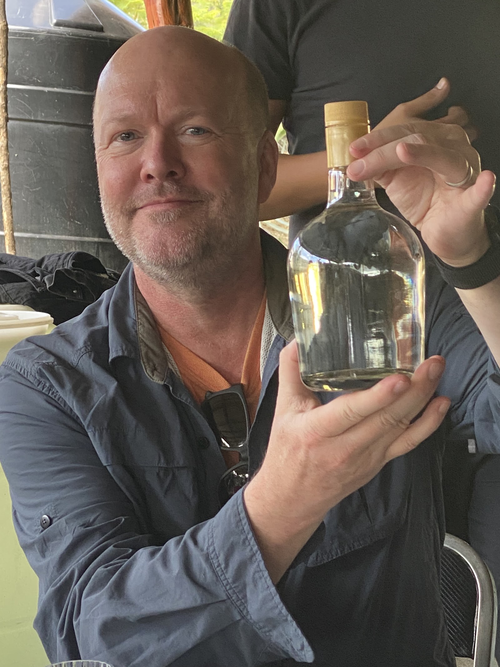 holding a clear mezcal bottle